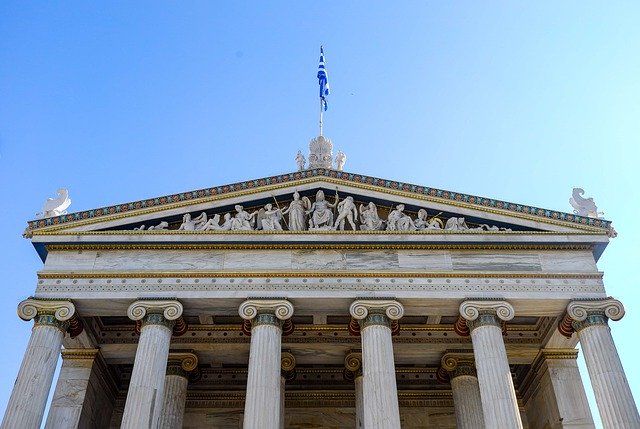 A building with columns and statues on top of it.