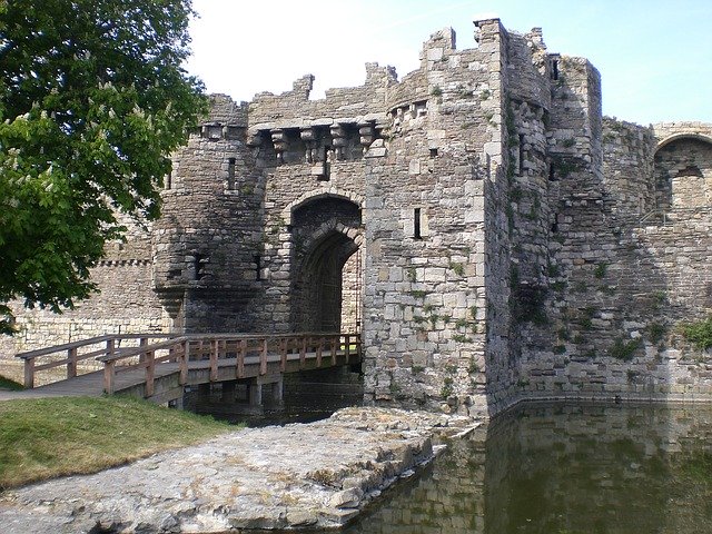 A stone bridge crossing over water near a castle.