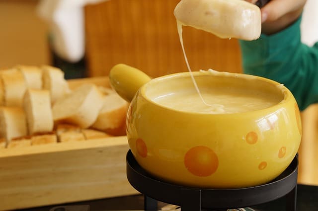 A yellow bowl of soup is being poured into it.