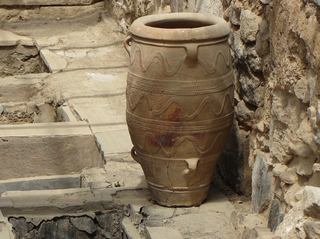 A large vase sitting on the ground near some steps.