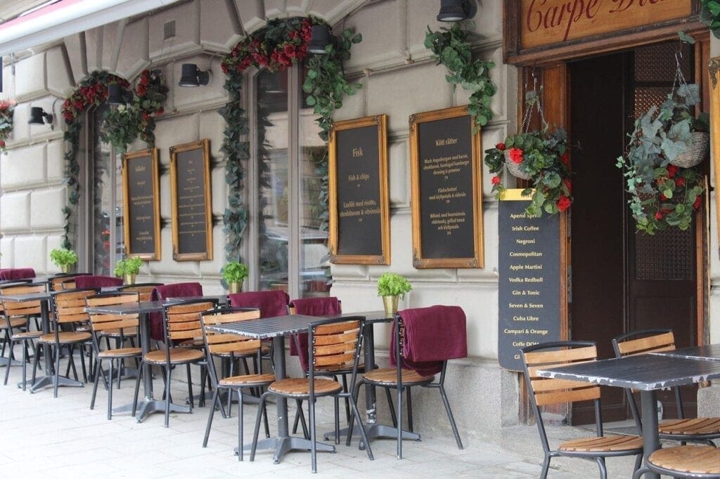 A restaurant with tables and chairs outside of it