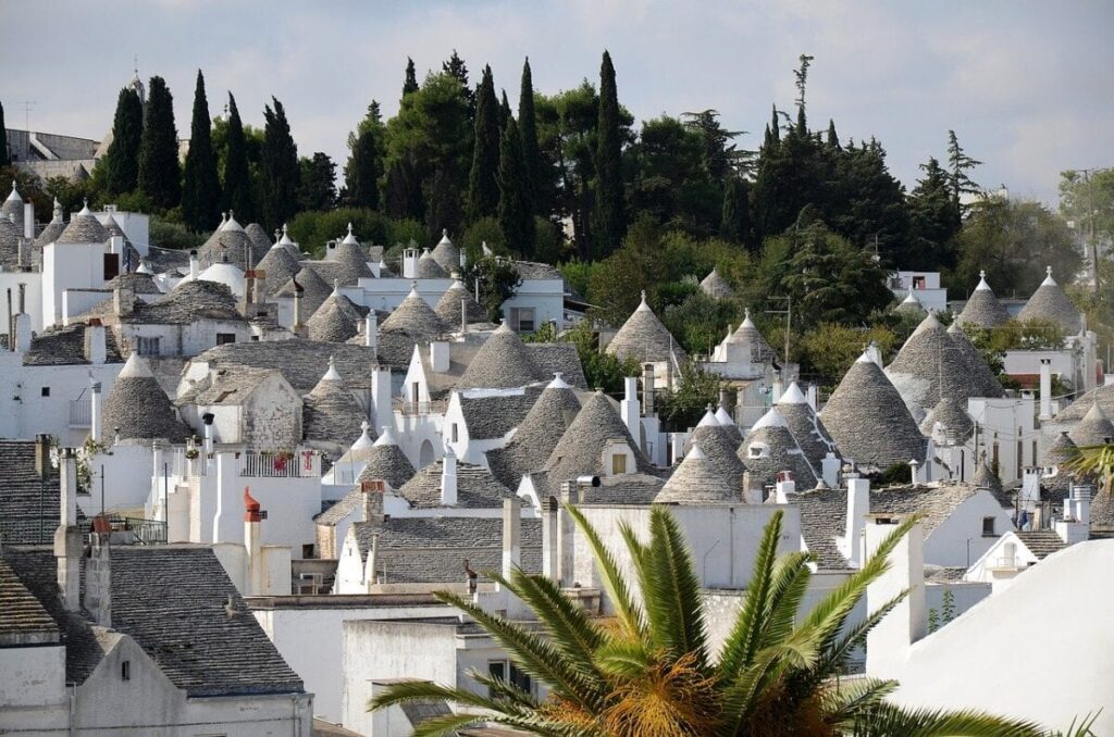 A view of many white houses with conical roofs.