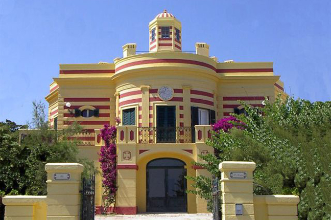 A yellow building with red trim and a clock.