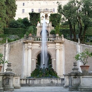 A fountain in the middle of an old garden.